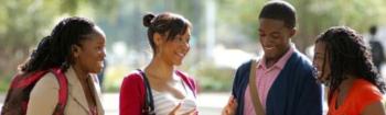 students smiling and conversing outdoors