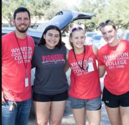 four people in red shirts with 'pioneer' text