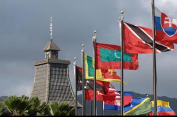 tower with flags of various countries against clouds