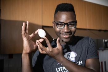 student smiling, juggling an egg