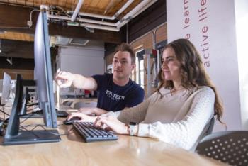 two students at a computer in makerspace