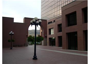 empty plaza with arched entrance and modern buildings