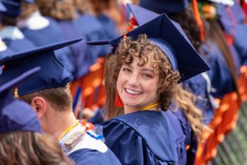 smiling graduate in blue cap and gown