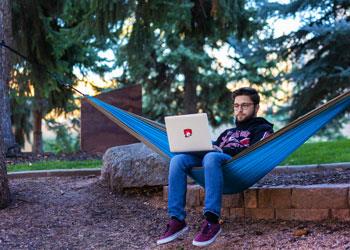 student in hammock with laptop