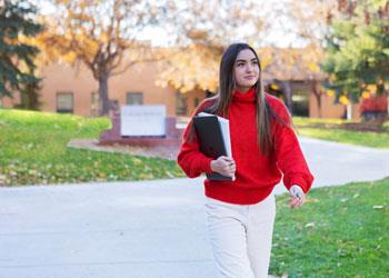 student walking with notebook