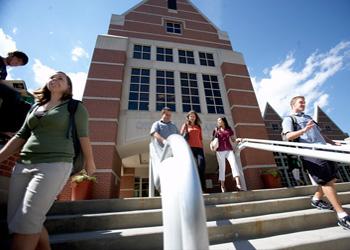 students walking near a modern building on a sunny day