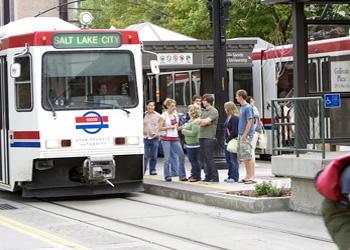 people waiting at a tram station with 'salt lake city' tram