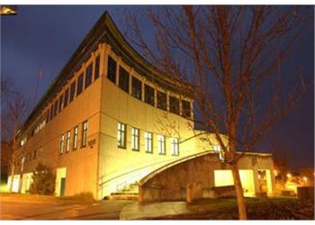 illuminated building at dusk with trees