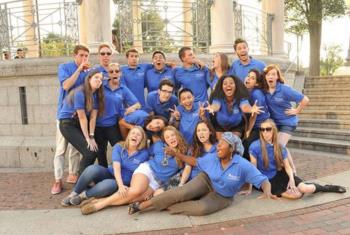 group of students in blue shirts posing playfully