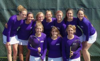 female tennis team in matching uniforms with racquets