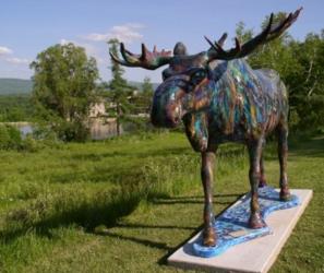 painted moose sculpture on a field with hills