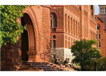 students on steps of ornate brick building