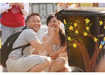 two people sitting, smiling by a decorated bin