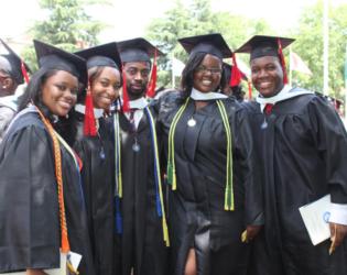 graduates smiling in caps and gowns