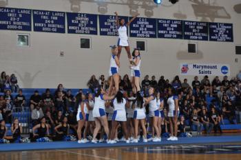 cheerleaders performing a stunt at a sporting event