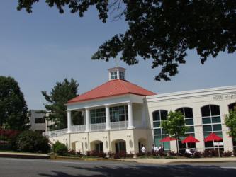 red-roofed building with outdoor seating and trees