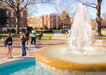 students near a fountain on campus