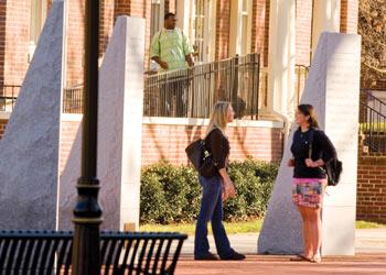 students walking by stone pillars