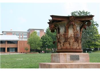 rusty sculptural urn in a grassy field