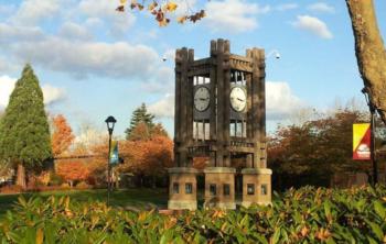 clock tower on campus with autumn leaves