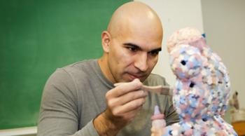 man feeding a teddy bear with a spoon