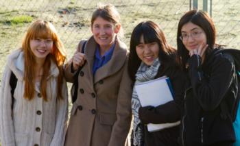 four students smiling outdoors