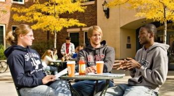 students chatting with coffee cups