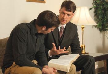 two individuals discussing over a book