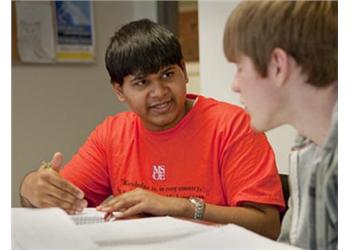 two students discussing over papers