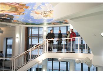 three people conversing on a staircase