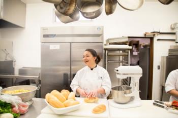 chef smiling while preparing food in a kitchen