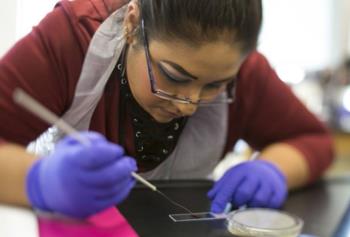 student working in lab with petri dish