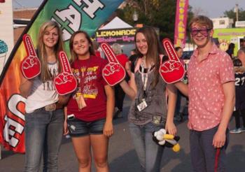 students with foam fingers at an outdoor event