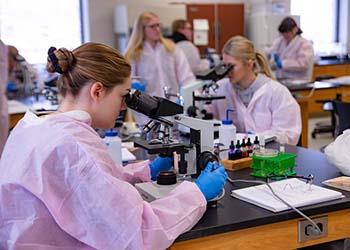 students using microscopes in a science lab