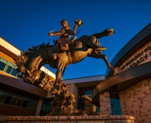 bronze cowboy statue at sunset