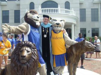 mascots with individual in academic regalia