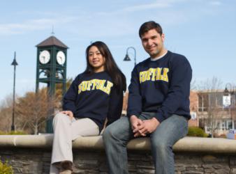 two people in college sweatshirts near clock tower