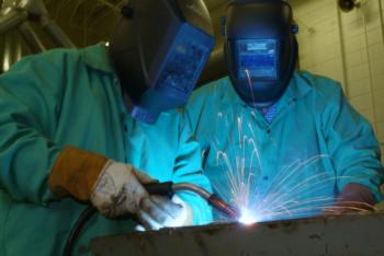 two people welding in workshop