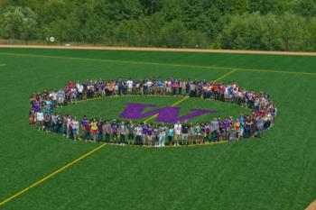 aerial view of people forming 'w' on field