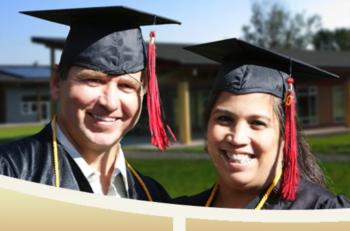 two graduates holding diplomas