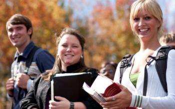 students walking with books in autumn