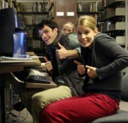 students giving thumbs up in a library