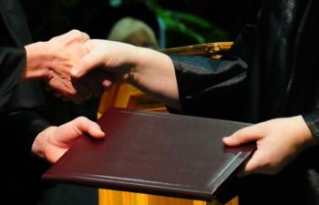 person receiving diploma at graduation ceremony