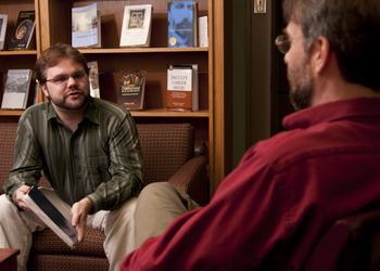 two individuals having a conversation in a cozy room