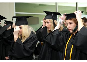 graduates adjusting caps during ceremony