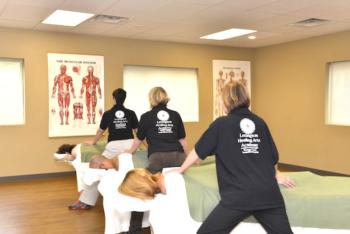 people practicing massage in a classroom