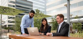 three professionals with a laptop outdoors