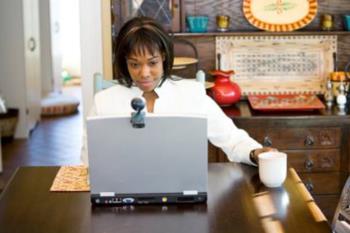 woman using a laptop at home with a cup of coffee