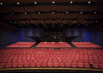 empty theater with red seats and a stage