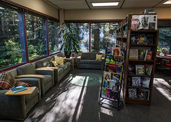 cozy campus lounge with sofas, bookshelf, and large window